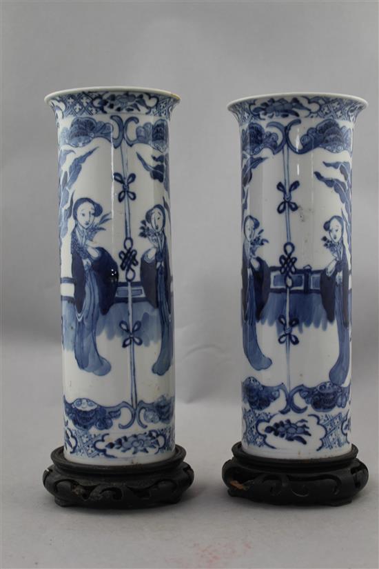 A pair of Chinese blue and white Long Eliza cylindrical vases, late 19th century, 26cm., ebonised wood stands